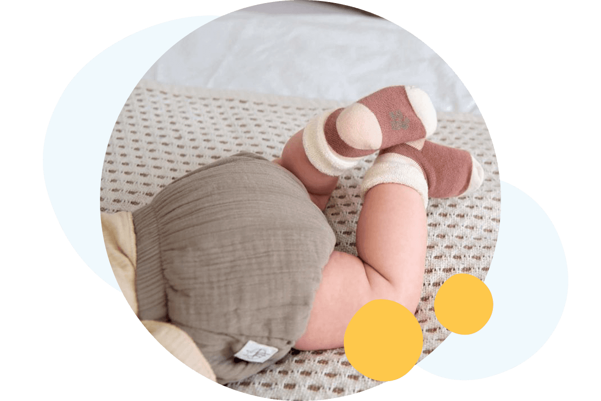A baby wearing linen culottes and terry socks